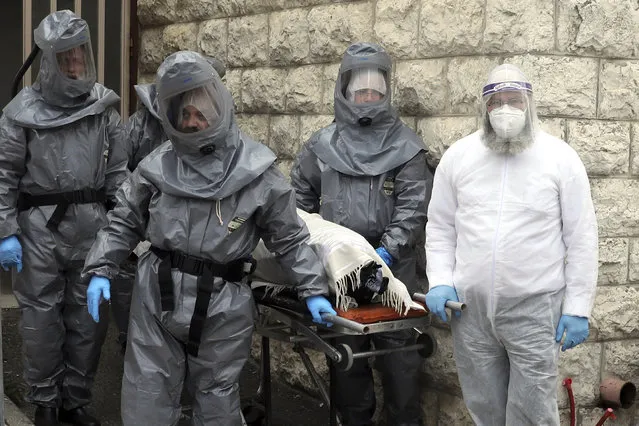 Members of Hevra Kadisha, an organization which prepares bodies of deceased Jews for burial according to Jewish tradition, take away a body of a person who died from coronavirus in Jerusalem, Wednesday, April 1, 2020. (Photo by Mahmoud Illean/AP Photo)