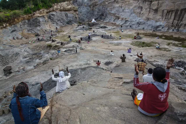 Father Pedro (back), founder of the Akamasoa association, conducts the traditional great mass celebrating Easter in a granite quarry in Antananarivo on April 12, 2020, while respecting the rules of social distancing required since the lockdown of Antananarivo from March 23, 2020, to curb the spread of the COVID-19 coronavirus. (Photo by Rijasolo/AFP Photo)