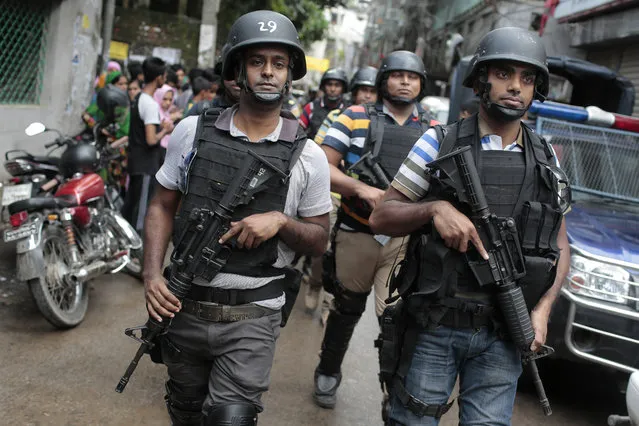 Members of a Bangladeshi special force leave the premises of a five-story building that was raided by police in Dhaka, Bangladesh, Tuesday, July 26, 2016. Police in Bangladesh's capital raided a five-story building Tuesday that was used as a den by suspected Islamic militants, killing nine of them, the country's police chief said. Police said they belonged to a Bangladeshi group blamed for an attack on a Dhaka cafe earlier this month in which 20 hostages, mostly foreigners, were killed and had been planning another large-scale assault. (Photo by AP Photo)