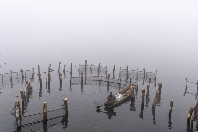 A Kashmiri rows his Shikara, or wooded boat, on a cold and foggy morning in the outskirts of Srinagar, Indian controlled Kashmir, Friday, January 3, 2025. (Photo by Dar Yasin/AP Photo)