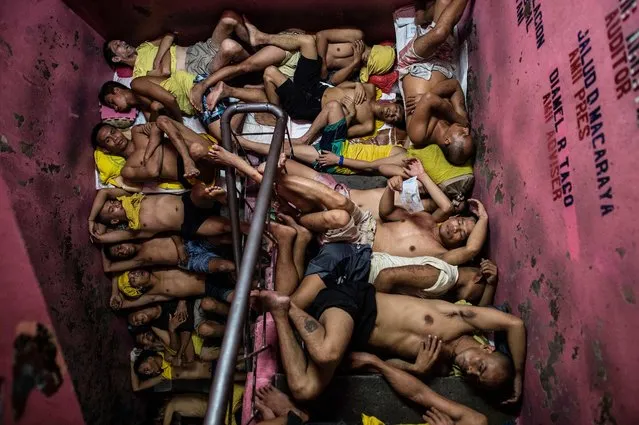 Inmates sleep on the steps of a ladder inside the Quezon City jail at night in Manila in this picture taken on July 21, 2016. (Photo by Noel Celis/AFP Photo)