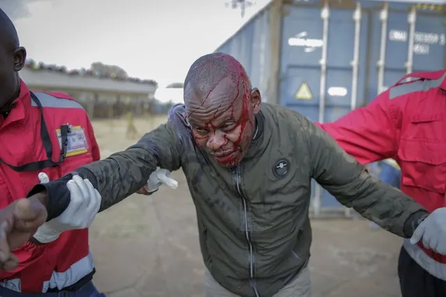 Medics treat an injured man who was beaten by police after people broke through barriers causing a stampede as they tried to force their way into Kasarani stadium where the inauguration of Kenya's new president William Ruto is due to take place later today, in Nairobi, Kenya Tuesday, September 13, 2022. (Photo by Brian Inganga/AP Photo)