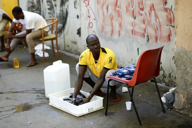 A migrant washes his clothes at a makeshift camp in Via Cupa (Gloomy Street) in downtown Rome, Italy, August 1, 2016. (Photo by Max Rossi/Reuters)