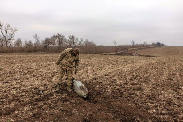 A Ukrainian military deminer checks on a Russian aerial-guided bomb in a field in Ukraine’s Dnipropetrovsk region on Thursday, January 30, 2025. (Photo by Roman Pilipey/AFP Photo)