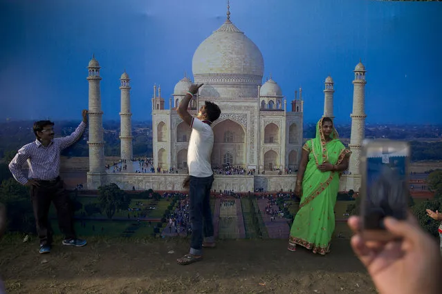 Indians get themselves photographed infront of a photo of Taj Mahal at a food and culture festival being held near the India Gate war memorial as part of Independence Day celebrations in New Delhi, India, Monday, August 15, 2016. India gained its independence from British colonial rule on this day in 1947. (Photo by Tsering Topgyal/AP Photo)