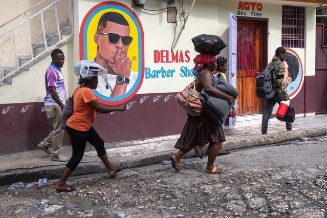 People transporting their belongings in Port-au-Prince, Haiti, 14 November 2024. Thousands of people living in the areas of Solino, Nazon and Christ-Roi, in the heart of Port-au-Prince, have fled their homes fleeing the advance of armed gangs into new territories, despite the presence of the Multinational Security Support Force, led by Kenya. (Photo by Johnson Sabin/EPA/EFE)