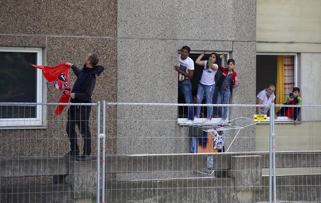Residents of the quarantined high-rise building are standing on windowsills and pursuing a police operation in Goettingen, Germany, Saturday, June 20, 2020. On Saturday the city wanted to carry out retesting of residents of the building complex. (Photo by Stefan Rampfel/dpa via AP Photo)