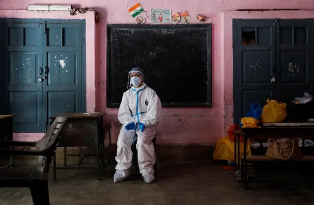 A medical worker sits inside a classroom as she takes a break at a school, which was turned into a centre to conduct tests for the coronavirus disease (COVID-19), amidst its spread in New Delhi, India on June 22, 2020. (Photo by Adnan Abidi/Reuters)