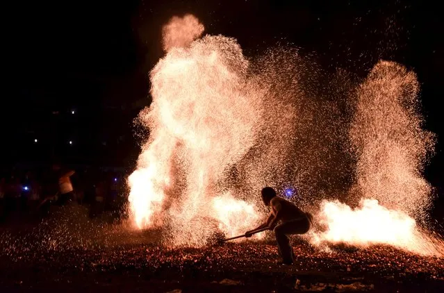 People take part in a performance next to a fire during a traditional ritual in Jinhua, Zhejiang province, September 18, 2015. (Photo by Reuters/Stringer)