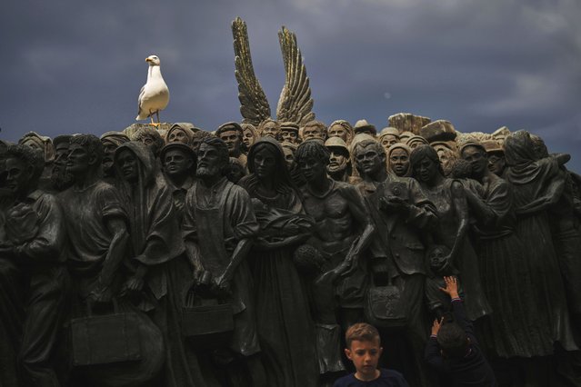 Children visit the “Angels Unaware” boat sculpture by Canadian artist Timothy P. Schmalz dedicated to migrants, as a seagull perches on its apex, in St. Peter's Square at the Vatican, April 28, 2025. (Photo by Francisco Seco/AP Photo)