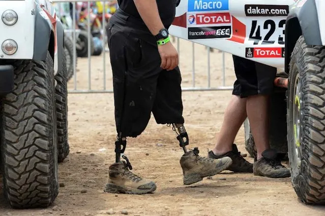 US Marine Corps former minesweeper Mark Zambon, member of the team Race 2 Recovery, consisting of British and US soldiers who have suffered serious injuries in the conflicts in Iraq and Afghanistan in recent years, enters a car in Lima on January 3, 2013, ahead of the 2013 Dakar Rally which this year will thunder through Peru, Argentina and Chile from January 5 to 20. (Photo by Frank Fife/AFP Photo)