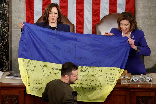 U.S. Vice President Kamala Harris and U.S. House Speaker Nancy Pelosi (D-CA) hold an Ukrainian flag as Ukraine's President Volodymyr Zelenskiy attends a joint meeting of the U.S. Congress in the House Chamber of the U.S. Capitol in Washington, U.S., December 21, 2022. (Photo by Evelyn Hockstein/Reuters)