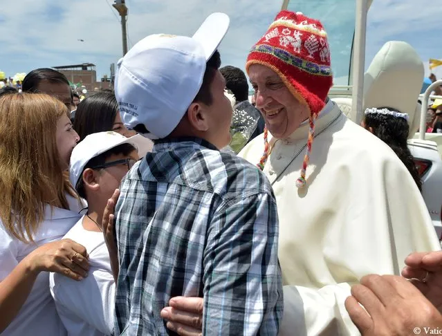 Pope Francis wearing typical Peruvian cap (Uchu) greets a boy in Plaza de Armas square in Buenos Aires neighborhood, southeast of Peruvian city Trujillo, on January 20, 2018. Pope Francis headed to Buenos Aires neighborhood, affected last March by “El Nino” weather pattern, after an open-air mass he officiated at the beach resort town of Huanchaco. (Photo by Osservatore Romano/AFP Photo/HO)