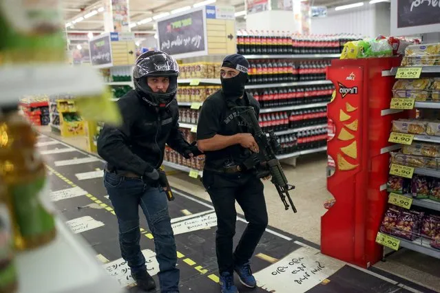 Israeli undercover security personal search a supermarket inside the Central Jerusalem Bus Station after police said a woman was stabbed by a Palestinian outside the bus station October 14, 2015. (Photo by Noam Moskowitz/Reuters)