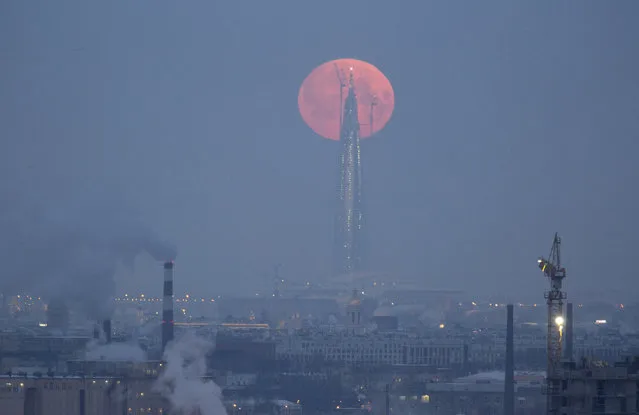 A full moon is seen behind the business tower Lakhta Centre, which is under construction in St. Petersburg, Russia, January 31, 2018. (Photo by Anton Vaganov/Reuters)