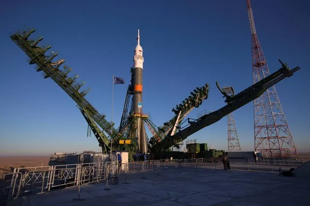 Service towers lift the Russia's Soyuz-FG booster rocket with the space capsule Soyuz TMA-15M that will carry a new crew to the International Space Station (ISS) at the launch pad at the Russian leased Baikonur cosmodrome, Kazakhstan, Friday, November 21, 2014. (Photo by Dmitry Lovetsky/AP Photo)