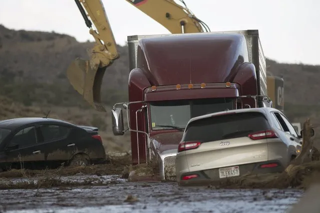 Workers dig out cars and trucks mired in mud and debris on State Route 58 near Tehachapi, California, about 60 miles (97km) outside of Los Angeles, October 17, 2015.  A mudslide on Thursday left nearly 200 vehicles, including 75 semi-trailer trucks, stuck in up to five feet of mud, local sheriff's spokesman Ray Pruitt said. (Photo by David McNew/Reuters)