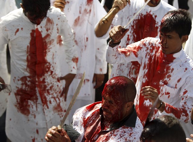 Iraq Shi'ite Muslim men bleed as they gash their foreheads with swords and beat themselves as they commemorate Ashura in Baghdad, October 24, 2015. (Photo by Ahmed Saad/Reuters)