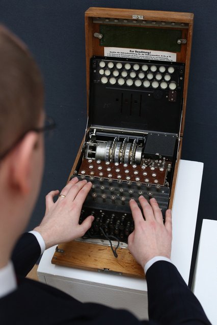 An employee at Christie's auction house examines an Enigma cipher machine on March 27, 2013 in London, England. The Enigma machine is expected to fetch 60,000 GBP when it features in Christie's “Travel, Science and Natural History” sale, which is to be held on April 24, 2013 in London.  (Photo by Oli Scarff)