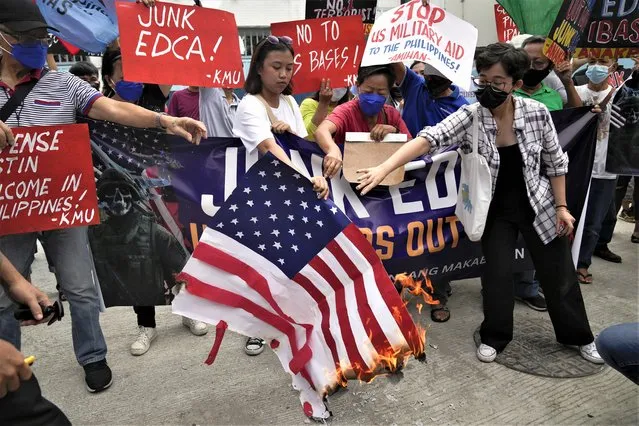 Demonstrators burn a mock U.S. flag as they protest against the visit of U.S. Defense Secretary Lloyd Austin outside Camp Aguinaldo military headquarters in metro Manila, Philippines on Thursday, February 2, 2023. Austin is in the Philippines for talks about deploying U.S. forces and weapons in more Philippine military camps to ramp up deterrence against China's increasingly aggressive actions toward Taiwan and in the disputed South China Sea. (Photo by Aaron Favila/AP Photo)