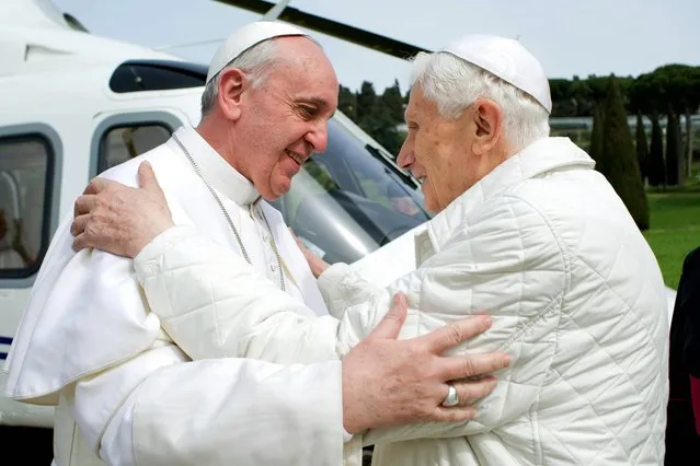 In this photo provided by the Vatican paper L'Osservatore Romano, Pope Francis meets Pope emeritus Benedict XVI in Castel Gandolfo Saturday, March 23, 2013. Pope Francis has traveled to Castel Gandolfo to have lunch with his predecessor Benedict XVI in a historic and potentially problematic melding of the papacies that has never before confronted the Catholic Church. The Vatican said the two popes embraced on the helipad. In the chapel where they prayed together, Benedict offered Francis the traditional kneeler used by the pope. Francis refused to take it alone, saying “We're brothers”, and the two prayed together on the same one. (Photo by Osservatore Romano/AP Photo/HO)