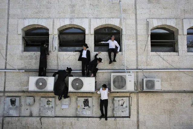 Ultra-Orthodox Jewish boys climb down a wall near the scene of a suspected attack in Jerusalem, in this August 4, 2014 file photo. (Photo by Ammar Awad/Reuters)