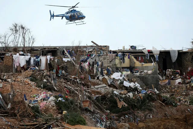 A helicopter flies over destroyed houses after Hurricane Matthew passes Jeremie, Haiti, October 7, 2016. (Photo by Carlos Garcia Rawlins/Reuters)
