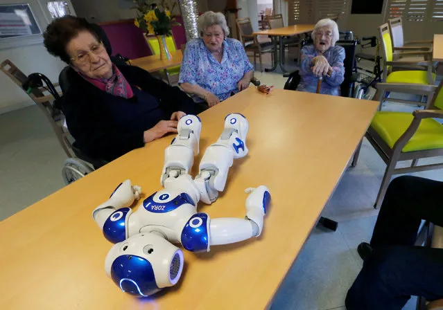 Elderly people play with a robot named NAO, manufactured by Softbank Robotics, in their retirement home in Bordeaux, France, March 16, 2018. (Photo by Regis Duvignau/Reuters)