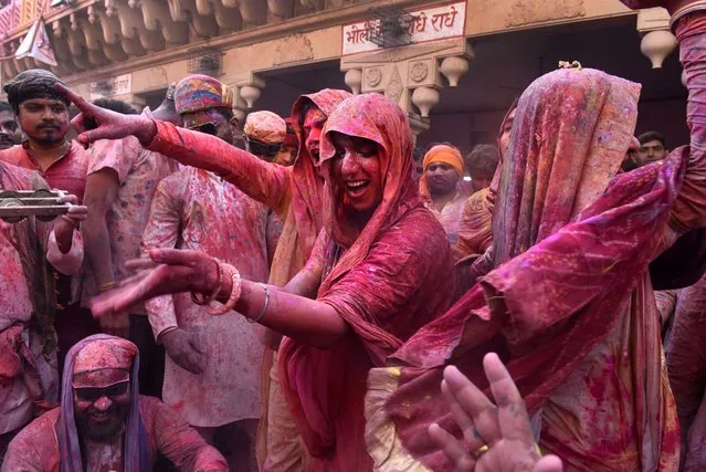 People smeared with colors play Holi at Nandagram temple in Nandgoan village, 115 kilometers (70 miles) south of New Delhi, India, Wednesday, March 1, 2023. (Photo by Deepanshu Aggarwal/AP Photo)
