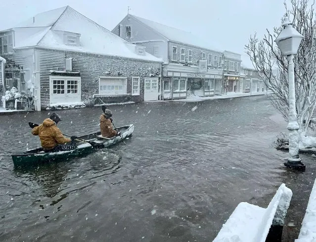 Nantucket High School students row a canoe along a road during heavy flooding, in Nantucket, Massachusetts, U.S. January 29, 2022 in this picture obtained from social media. (Photo by Ian Williams via Reuters)