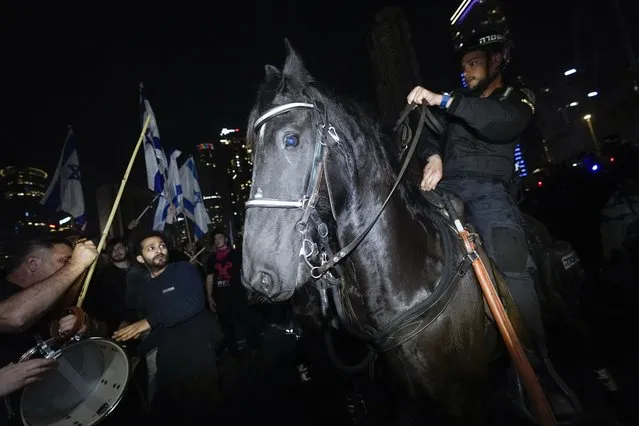 An Israeli mounted police officer disperses demonstrators as they block a main road during a protest against plans by Prime Minister Benjamin Netanyahu's new government to overhaul the judicial system, in Tel Aviv, Israel, Saturday, March 4, 2023. (Photo by Ohad Zwigenberg/AP Photo)