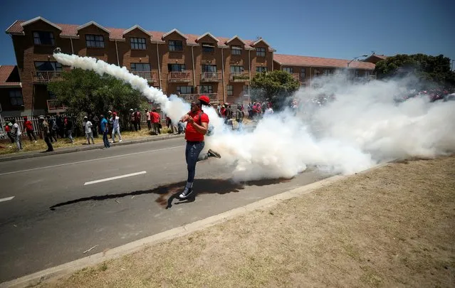 A protester throws a teargas can back at the police during the opposition Economic Freedom Fighters party's protest against alleged racism outside Brackenfell High School in Cape Town, South Africa, November 20, 2020. (Photo by Mike Hutchings/Reuters)