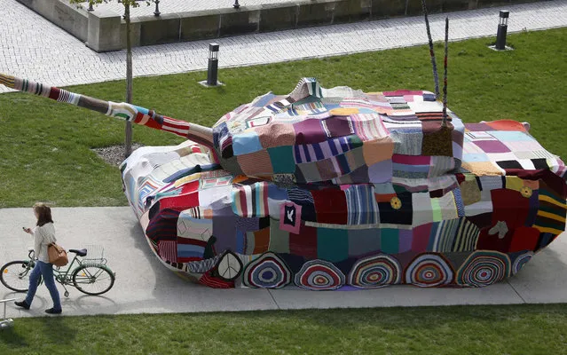 A woman pushes her bicycle next to a German Leopard 1 tank in front of the Museum of Military History in Dresden April 25, 2013. The tank is covered with knitting made by Dresden citizens, called “Attack! Knitting for peace. Taking a stand against war and violence with a cross-generational handicrafts project”. (Photo by Fabrizio Bensch/Reuters)