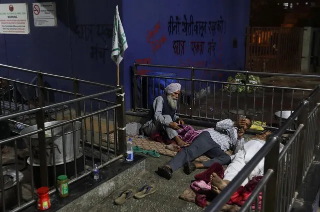 Farmers get ready to sleep outside a metro station as they protest against newly passed farm bills at Tikri border near Delhi, India, December 11, 2020. (Photo by Anushree Fadnavis/Reuters)