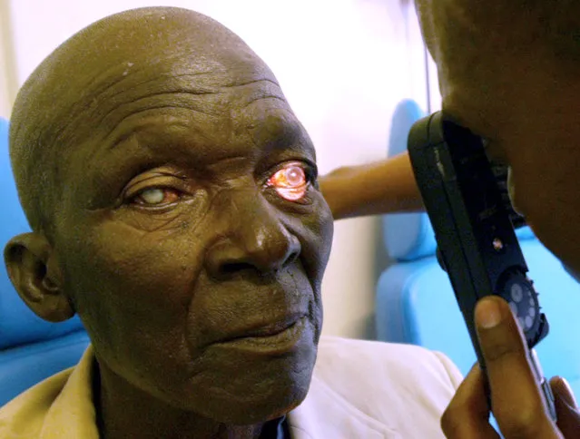 A student doctor conducts an eye test at Kimberley train station in South Africa June 29, 2004. (Photo by Juda Ngwenya/Reuters)