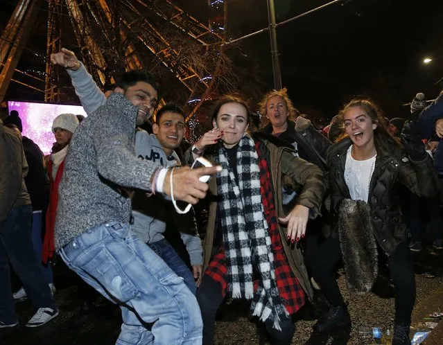 Revellers celebrate the New Year in Princes Street during Hogmanay street party celebrations in Edinburgh, Scotland January 1, 2015. (Photo by Russell Cheyne/Reuters)