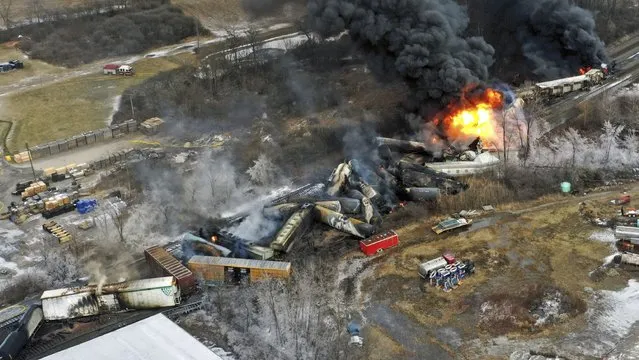 This photo taken with a drone shows portions of a Norfolk and Southern freight train that derailed Friday night in East Palestine, Ohio are still on fire at mid-day Saturday, February 4, 2023. (Photo by Gene J. Puskar/AP Photo)