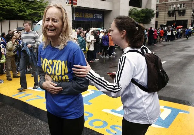Pam Vingsness comforts her crying mother, Rachel, of Newton, Massachusetts, on May 25, 2013, after they crossed the finish line, as runners who were unable to finish the Boston Marathon on April 15 because of the bombings were allowed to finish the last mile of the race. (Photo by Winslow Townson/Associated Press)