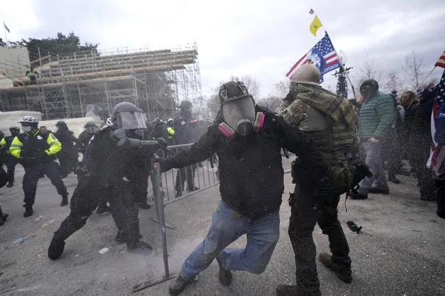 Trump supporters try to break through a police barrier, Wednesday, January 6, 2021, at the Capitol in Washington. (Photo by Julio Cortez/AP Photo)