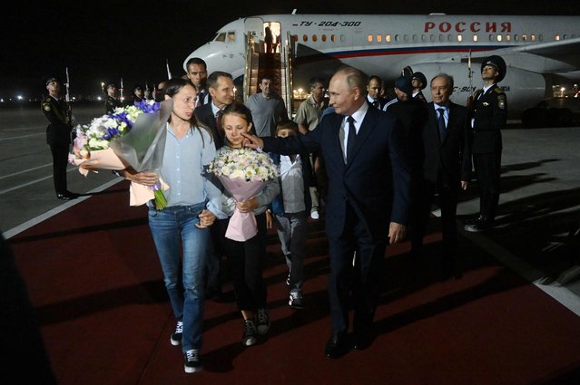 In this pool photograph distributed by Russian state agency Sputnik, Russia's President Vladimir Putin welcomes Russian citizens released in a major prisoner swap with the West, at Moscow's Vnukovo airport on August 1, 2024. (Photo by Mikhail Voskresenskiy/Pool via AFP Photo)