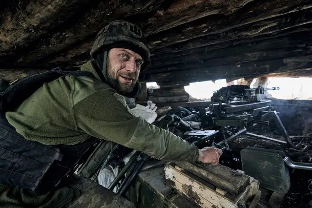 A Ukrainian soldier prepares to fire his machine gun in a dugout on the frontline in the village of New York, Donetsk region, Ukraine, Monday, April 24, 2023. (Photo by Libkos/AP Photo)