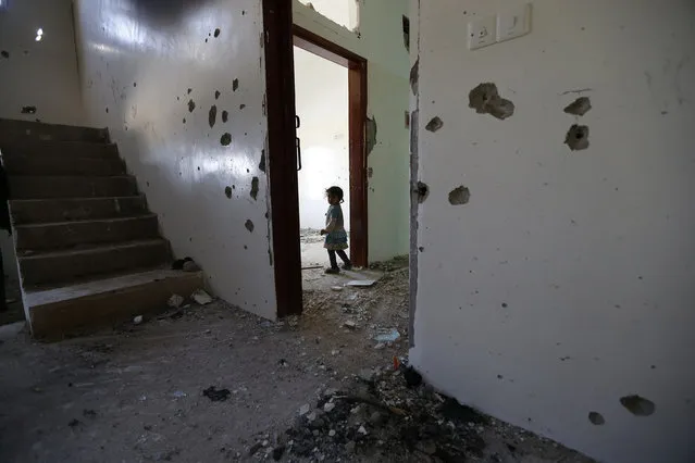 A girl is seen in her family's flat damaged during a police raid on a nearby hideout of al Qaeda militants in the Arhab region north of the Yemeni capital Sanaa May 27, 2014. (Photo by Khaled Abdullah/Reuters)