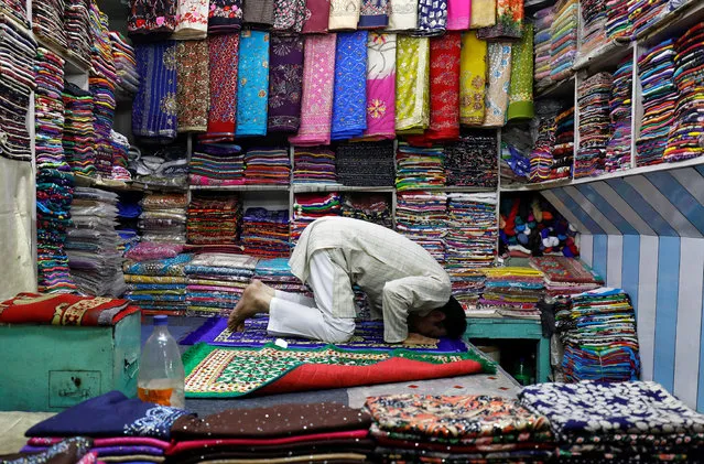 A Muslim man offers prayers at his shop after the Iftar (breaking fast) meal during the holy fasting month of Ramadan in the old quarters of Delhi, India, June 1, 2018. (Photo by Saumya Khandelwal/Reuters)