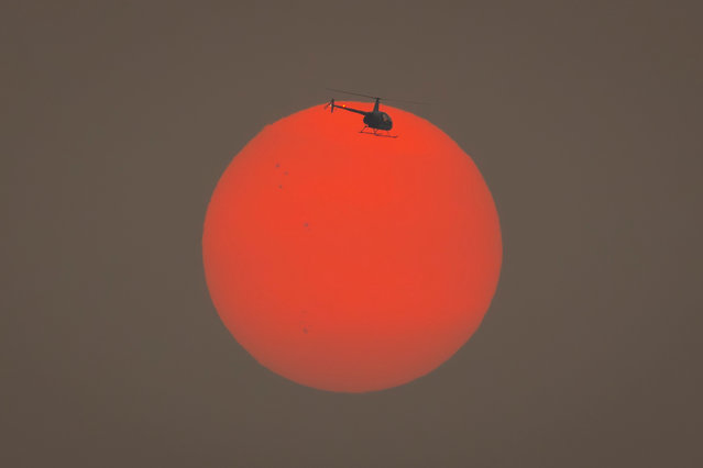 A helicopter flies through smoke from fires in Sao Paulo, Brazil, 05 September 2024. Most of Brazil is experiencing a strong impact from climate change this year, with unusually high temperatures for the Southern Hemisphere winter and severe drought affecting particularly the Amazon region. (Photo by Isaac Fontana/EPA/EFE)