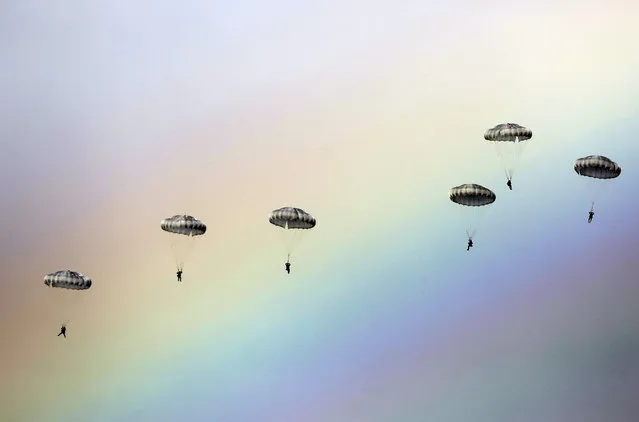 Russian paratroopers jump as a rainbow appears in the sky during the joint Russian, Belarusian and Serbian military exercise “The Slavic Brotherhood” at the military ground Kovin, near Belgrade, on November 7, 2016. (Photo by AFP Photo/Stringer)