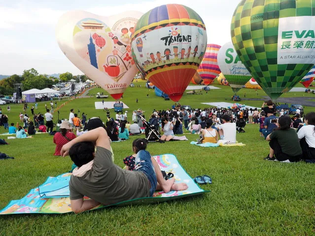 Tourists watch hot air balloons taking off at the 2018 Taiwan International Balloon Festival in Taitung County, southeastern Taiwan, 30 June 2018. The event will run from 30 June until 13 August, and will feature 39 hot air balloons from 18 countries. (Photo by David Chang/EPA/EFE)