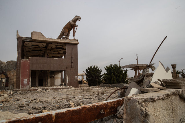 A dinosaur statues is seen on top of a ruined building at Hraytan distric on December 16, 2024 in Aleppo, Syria. Aleppo was the first major city to fall in last week's lightning offensive by rebel forces as they toppled Syria's Assad regime. (Photo by Burak Kara/Getty Images)