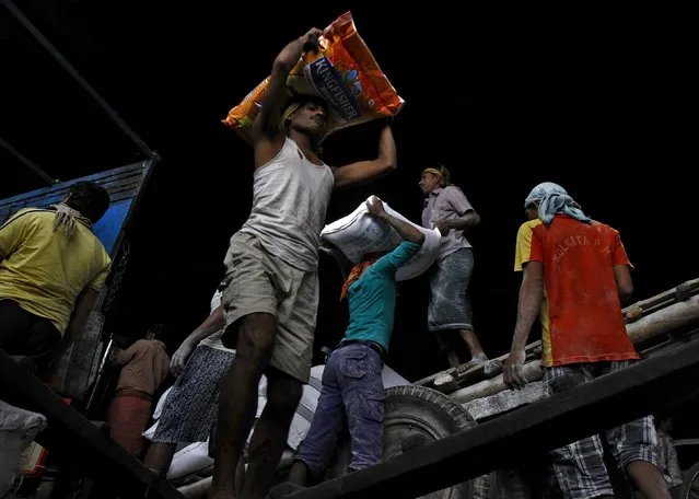 Labourers load sacks of flour and rice onto a supply truck at a wholesale market in Kolkata, India, December 14, 2015. India's wholesale prices fell for a 13th straight month in November, but a sharp pickup in food prices and a pending wage hike for millions of government employees are likely to keep policymakers worried about potential inflationary risks. (Photo by Rupak De Chowdhuri/Reuters)