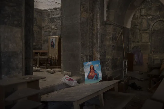 Pictures of Jesus Christ are seen inside a church damaged by Islamic State fighters during their occupation of Qaraqosh, east of Mosul, Iraq, Saturday, November 12, 2016. Qaraqosh, the biggest Christian town on the Nineveh plains in Iraq's north, fell to the Islamic State group in 2014 and was recently retaken by Iraqi government forces. (Photo by Felipe Dana/AP Photo)