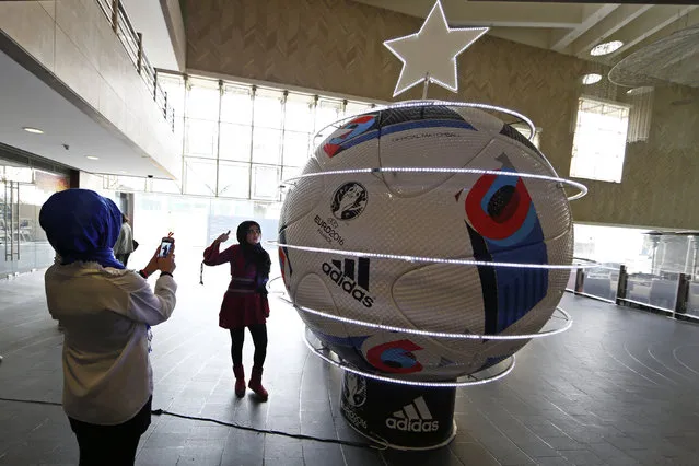 Youths take pictures near a decorated giant UEFA Euro 2016 soccer ball, dubbed “Beau Jeu” (Beautiful Game), in downtown Beirut, Lebanon December 17, 2015. (Photo by Jamal Saidi/Reuters)